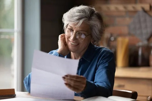 Woman smiling while reviewing a financial letter